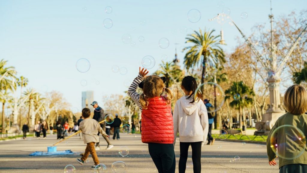 Children blowing bubbles in a park on a sunny day